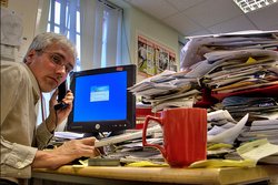 Un traballador nunha oficina falando por teléfono diante dun ordenador / Alan Cleaver Flickr