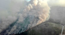 As brigadas  loitan contra o lume desde un helicóptero/ briflaza