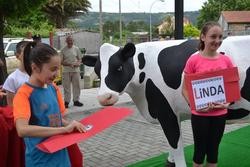 Nenos abrindo o sobre cos nomes das vacas de fibra de Mazaricos; Linda e Marela / Concello de Mazaricos