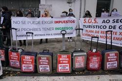 Traballadores de axencias de viaxe colocan maletas como signo de protesta nunha manifestación pola situación do sector convocada pola Asociación Plataforma en Defensa polas Axencias de Viaxe de Galicia fronte ao Parlamento galego, en Santiago de Com. Álvaro Ballesteros - Europa Press / Europa Press