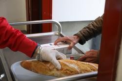 Un voluntario (i) trae comida a unha persoa (d) como parte da repartición diaria de alimentos do Comedor Social San José, en Puente de Vallecas, Madrid / Marta Fernández Jara - Europa Press