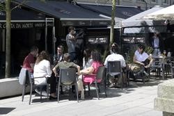 Un grupo de persoas reúnese nun local de hostalaría da Coruña tras entrar en vigor as novas medidas. M. DYLAN - EUROPA PRESS