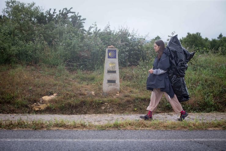 Unha peregrina camiña cara a Santiago de Compostela por onde transcorre o Camiño de Santiago francés / Carlos Castro - Europa Press.