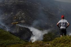 Un veciño de Senderiz en Lobeira observa un hidroavión traballar no incendio forestal na Serra do Leboreiro, no parque natural de Baixa Limia e Serra do Xurés / Rosa Veiga - Arquivo