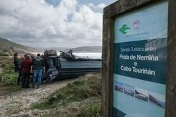 Membros da Garda Civil observan o interior da planadora varada na praia de Nemiña / Europa Press
