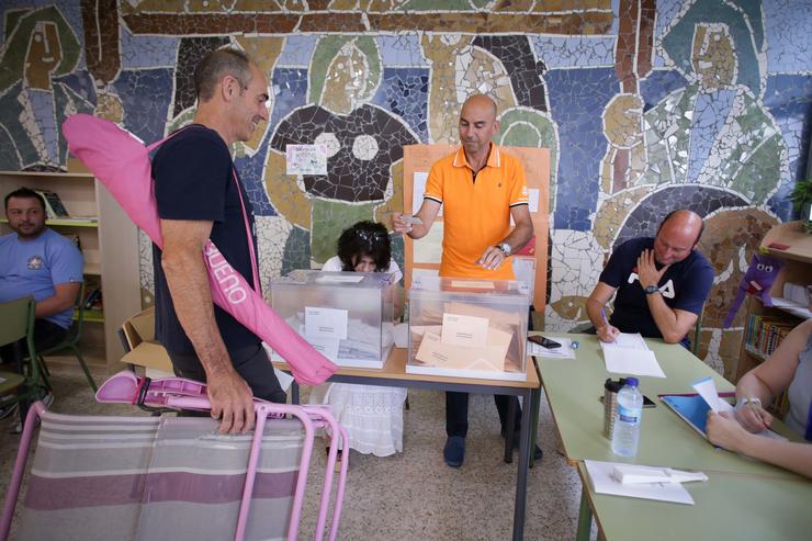 Unha persoa con indumentaria de praia exercen o seu dereito a voto durante as eleccións xerais, no Colexio Público Nº1, a 23 de xullo de 2023, en Foz / Carlos Castro