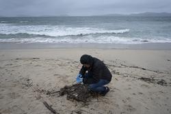 Un voluntario recolle pélets na praia de Samil. Adrián Irago - Europa Press / Europa Press