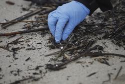 Un voluntario recolle pellets na praia de Samil, a 10 de xaneiro de 2024, en Vigo / Adrián Irago - Arquivo