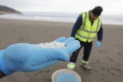 Arquivo - Un operario de TRAGSA colle coa man pellets de plástico, na praia Otur, a 9 de xaneiro de 2024, en Valdés, Asturias (España).. Jorge Peteiro - Europa Press - Arquivo