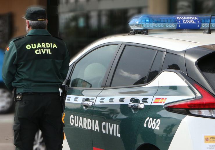 Un axente da Garda Civil, de costas, de pé xunto a un vehículo oficial / GARDA CIVIL - Arquivo