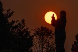 Saída do sol no Monte do Gozo en Santiago,  tinguido de vermello polo fume que chega a Galicia desde os incendios do norte de Portugal. A 19 de setembro de 2024 / ÁLVARO BALLESTEROS / Europa Press