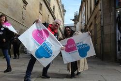 Dúas persoas sosteñen unha pancarta de Queremos Galego! a súa chegada á Praza do Obradoiro / Xornal de Compostela