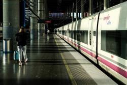 Unha muller camiña pola plataforma xunto a un tren de AVE de Renfe estacionado nas vías da Estación de Atocha. JESÚS HELLÍN / Europa Press