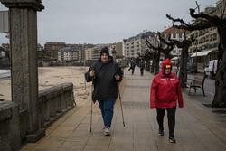Dúas persoas no paseo marítimo dunha praia da comarca de Salnés, a 27 de xaneiro de 2025 / Elena Fernández - Arquivo